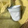 Элегантная керамическая кофейная чашка с тонкой текстурой и оригинальной, необычной формой.