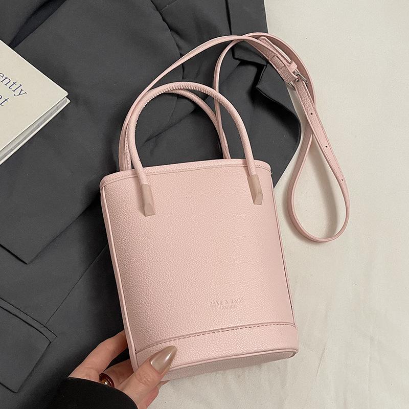 Оптовая продажа новых нишевых простых однотонных сумок-ведер с текстурой «личи», для ношения в руке, универсальных, в зарубежном стиле, для поездок на работу, мессенджеров, женских сумок