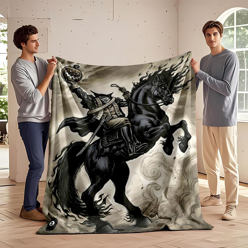 A headless rider on a black horse holding a sinister carved pumpkin. for all seasons blanket lunch break throw gift
