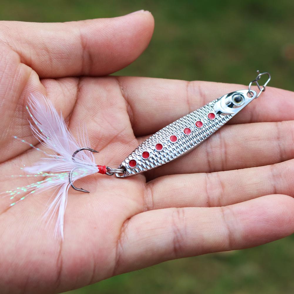 Серебристая металлическая приманка (маленькая рыбка, мормышка) с тройным крючком и пером