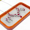 Gessen Jewelry: Элегантный набор: серьги, кольцо и подвеска с красными цирконами