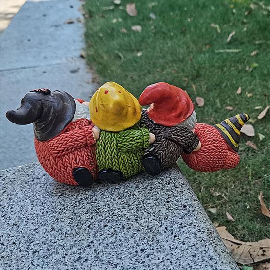 Рождественский гном, сидящий на полке, статуэтка, свисающая с края стола, четыре безликих