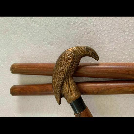 Старинная коричневая деревянная трость для ходьбы в рабочем стиле с ручкой в виде головы ворона.