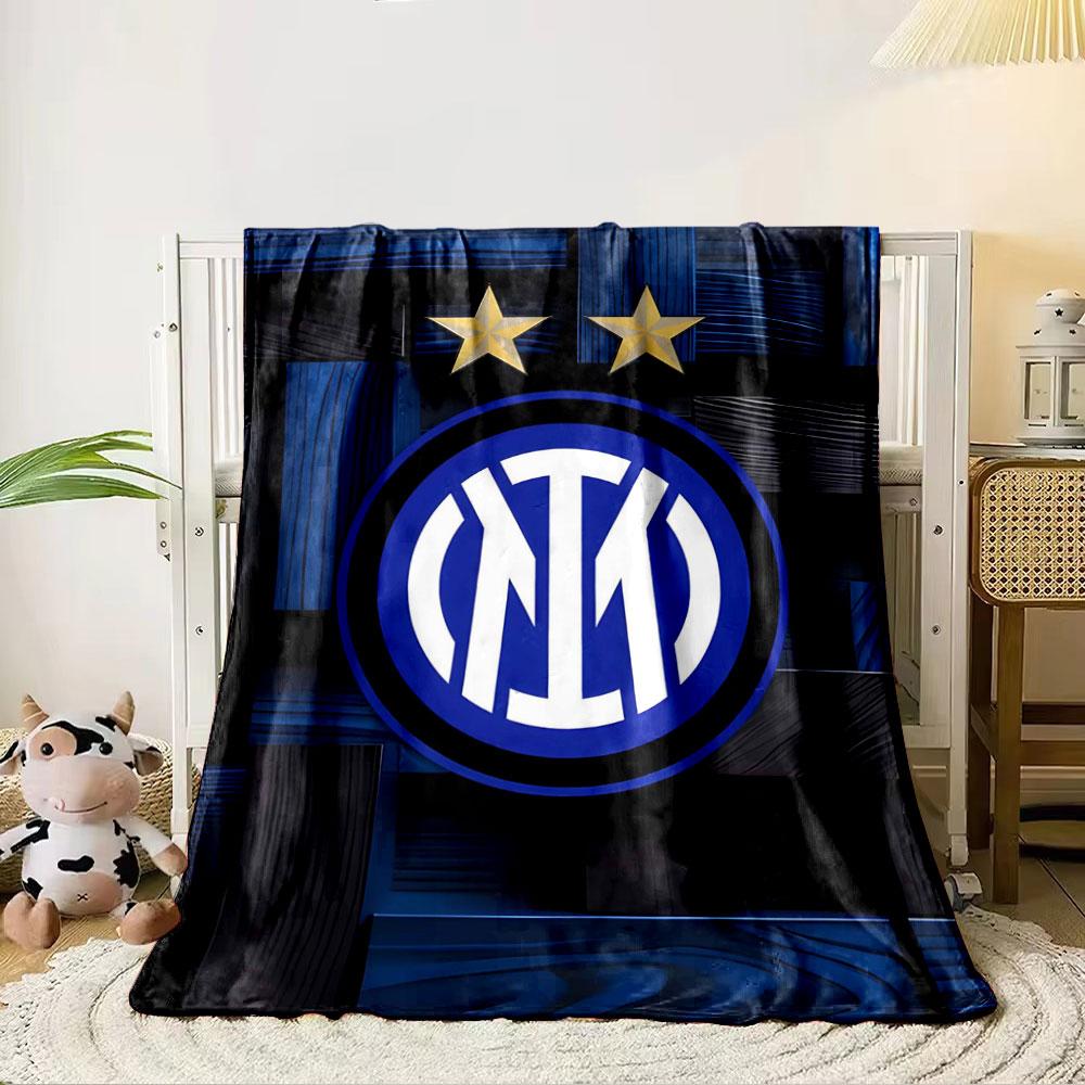 Intertwined white letters in a blue circle, two gold stars above, wood-like background. for all seasons blanket lunch break throw gift