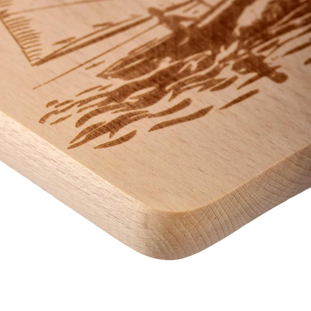 Wooden cutting board with an engraved sailboat