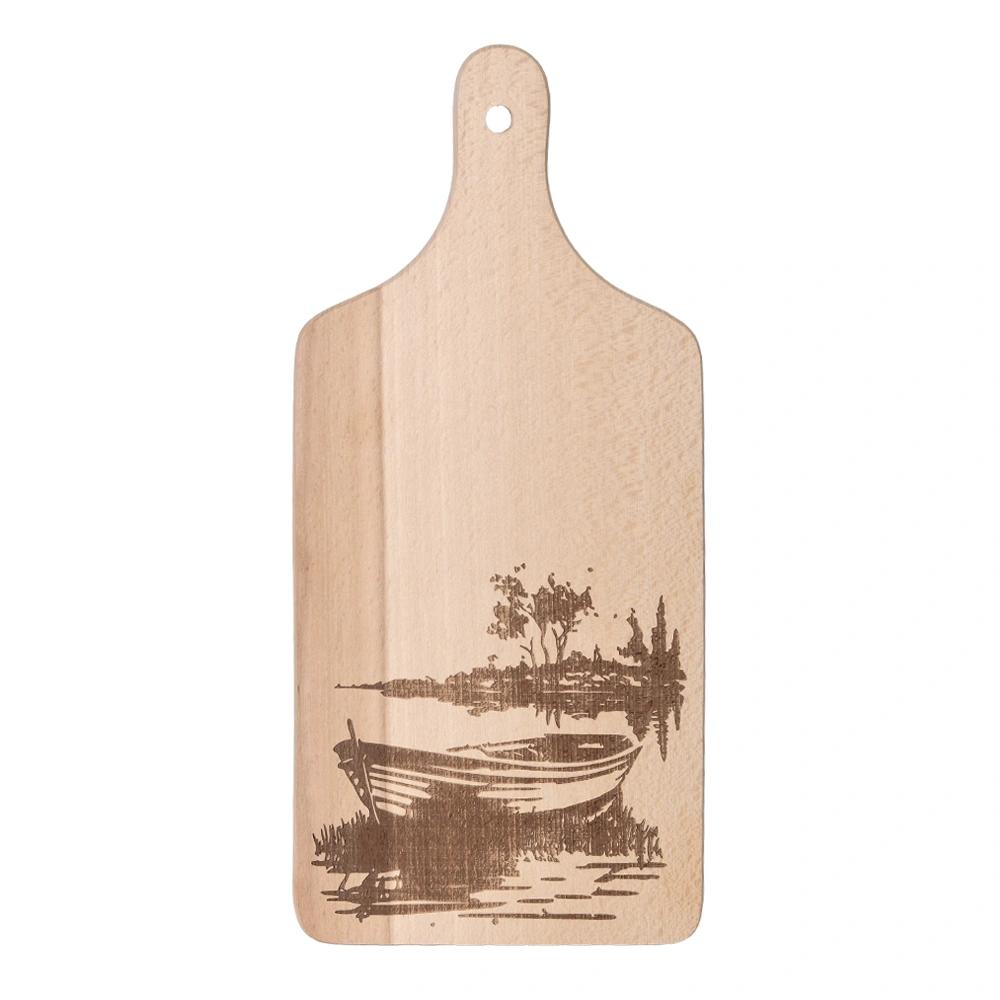 Wooden chopping board engraved with a boat on a lake