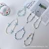Телефонный шнурок ручной работы с бусинами цвета морской соли и синими звездами
