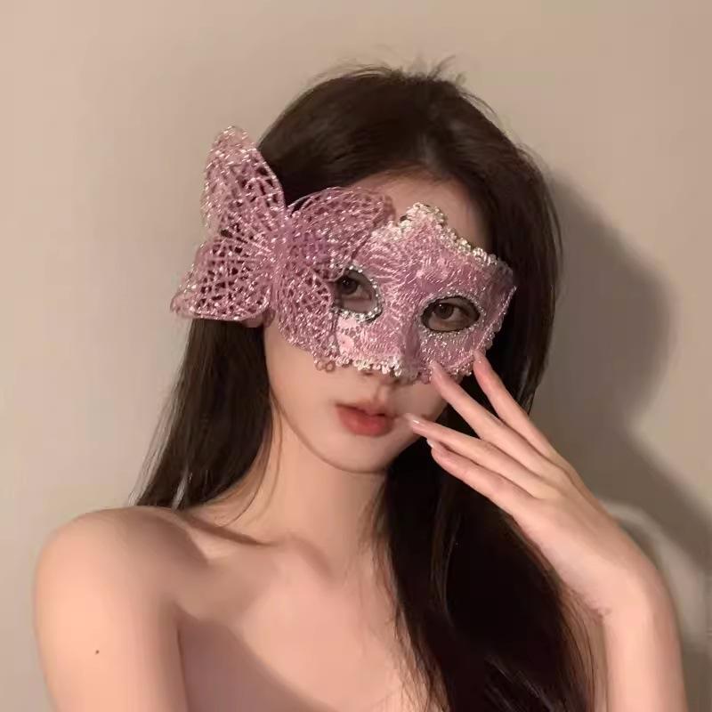 Cosmetic masquerade party with a sexy half-face makeup woman wearing a half-face erotic lace mask, a Halloween feather mask