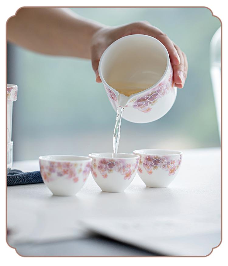 White Porcelain Floral Travel Tea Set: Includes One Pot, Three Cups, and Portable Bag.