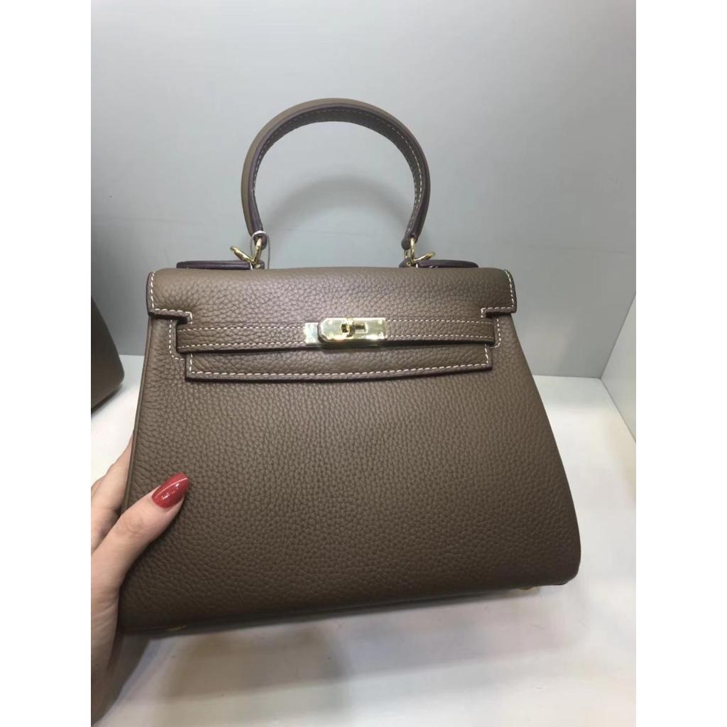 Келли обертывает верхний слой модной сумки-тоут из фактурной коровьей кожи, которую можно носить на плече или через плечо