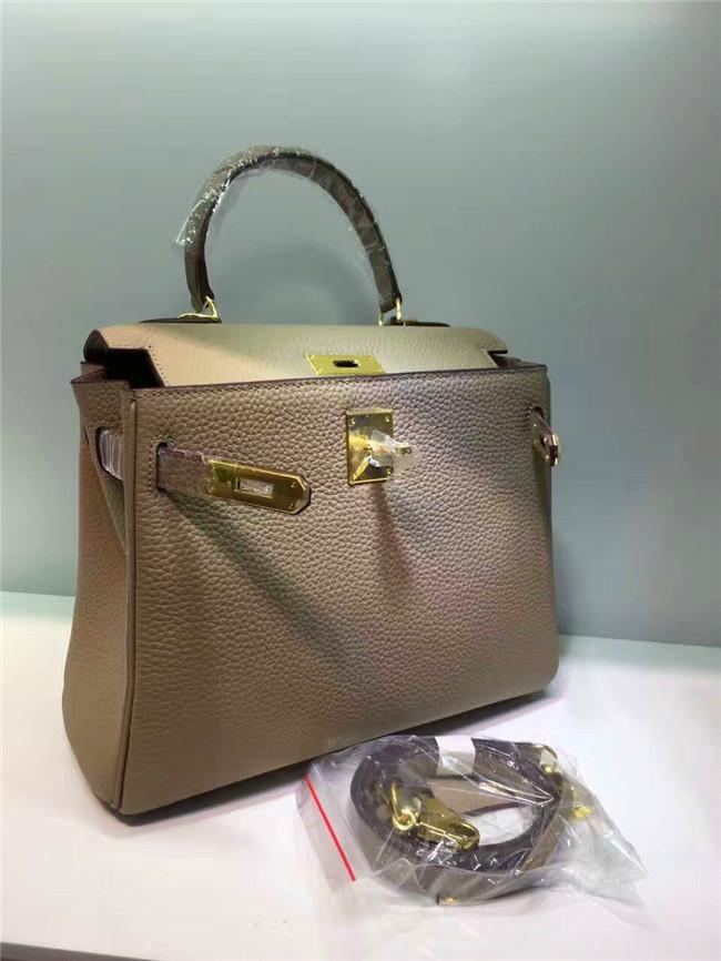 Келли обертывает верхний слой модной сумки-тоут из фактурной коровьей кожи, которую можно носить на плече или через плечо