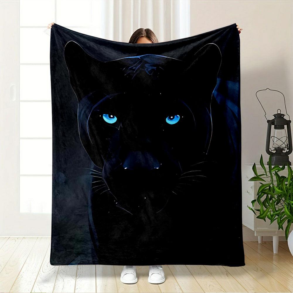 A sleek black panther with glowing blue eyes in a dark background. for all seasons blanket lunch break throw gift
