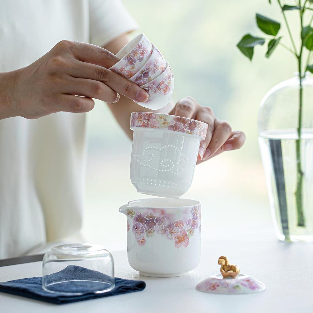 White Porcelain Floral Travel Tea Set: Includes One Pot, Three Cups, and Portable Bag.