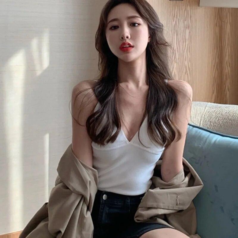 Подтяжки с глубоким V-образным вырезом и низким вырезом. Маленький жилет. Женщины носят топы без рукавов.