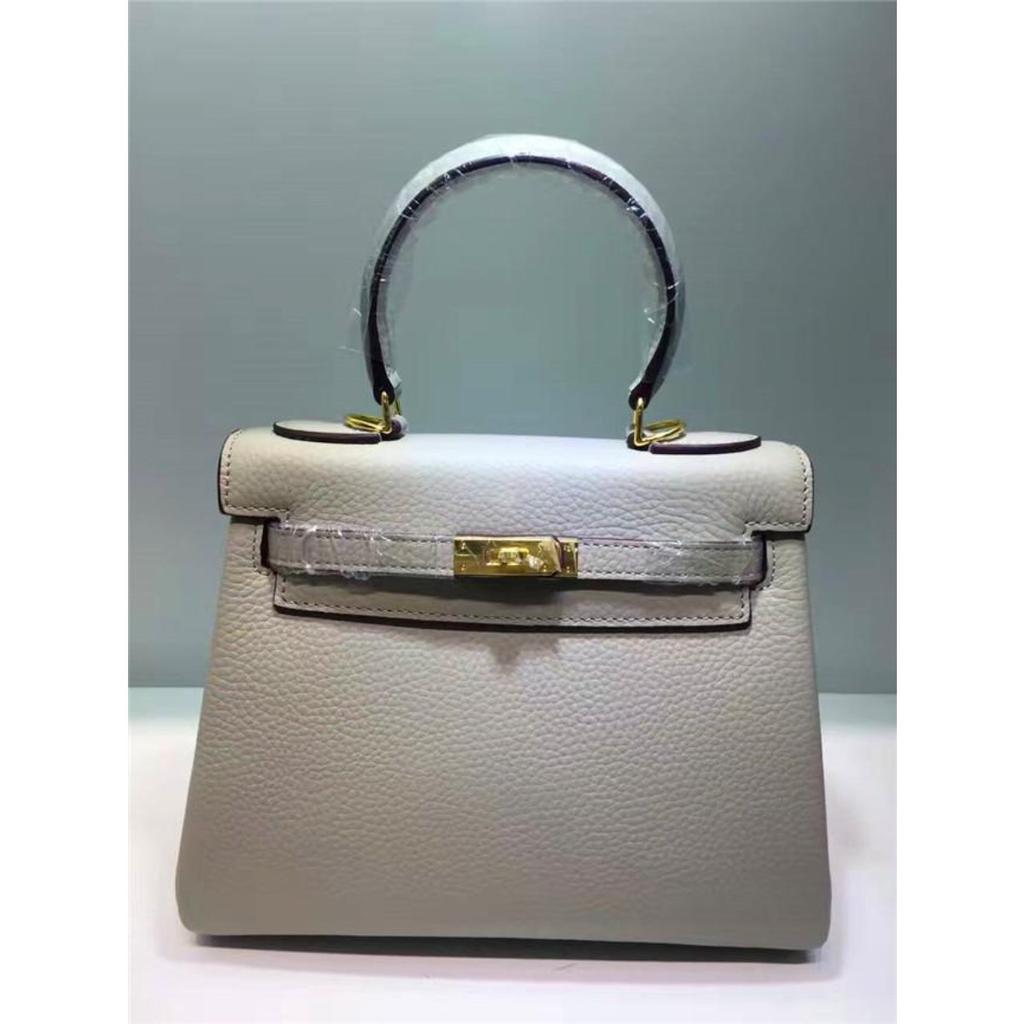 Келли обертывает верхний слой модной сумки-тоут из фактурной коровьей кожи, которую можно носить на плече или через плечо