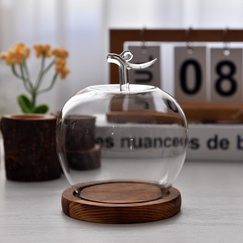 Купол из стекла с изображением вареных яблок и цветов, украшенный глиняной поделкой, для украшения рождественского стола.