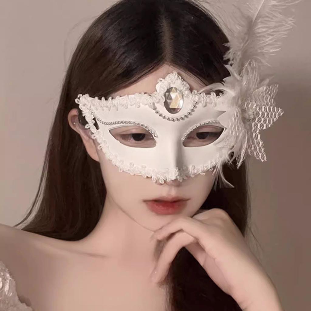 Cosmetic masquerade party with a sexy half-face makeup woman wearing a half-face erotic lace mask, a Halloween feather mask