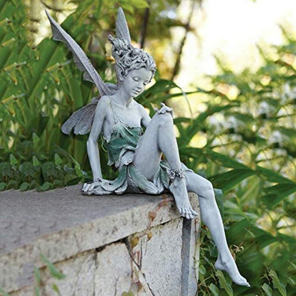 Statue of a seated angel with wings, garden decoration