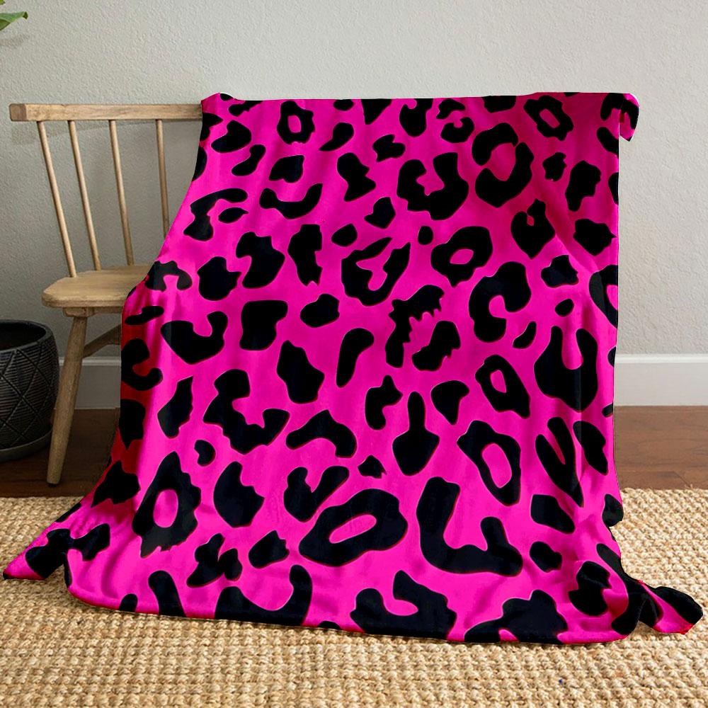 The pattern features irregular black leopard spots on a bright pink background. for all seasons blanket lunch break throw gift