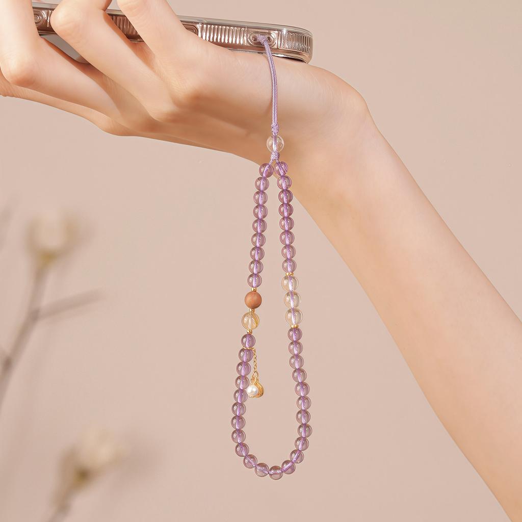 The Fortune Star Chain is a natural purple-white crystal, golden rutilated quartz, and pearl phone chain that attracts wealth, offering a light