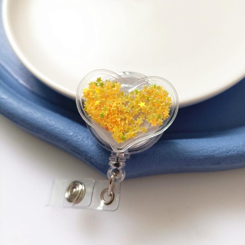 Новый стиль бейджа с мультяшной кнопкой-защелкой  Эластичная кнопка-защелка  Сердце с пересыпающимся песком  Изделие из смолы  Шнурок-держатель для ID-карты  Зажим-держатель