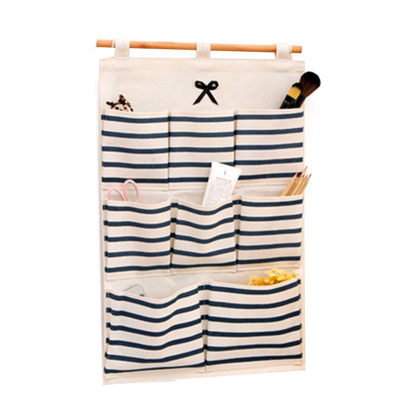 Полосатая настенная подвесная сумка для хранения из хлопка и льна с бантом и множеством карманов для кухни или ванной комнаты.