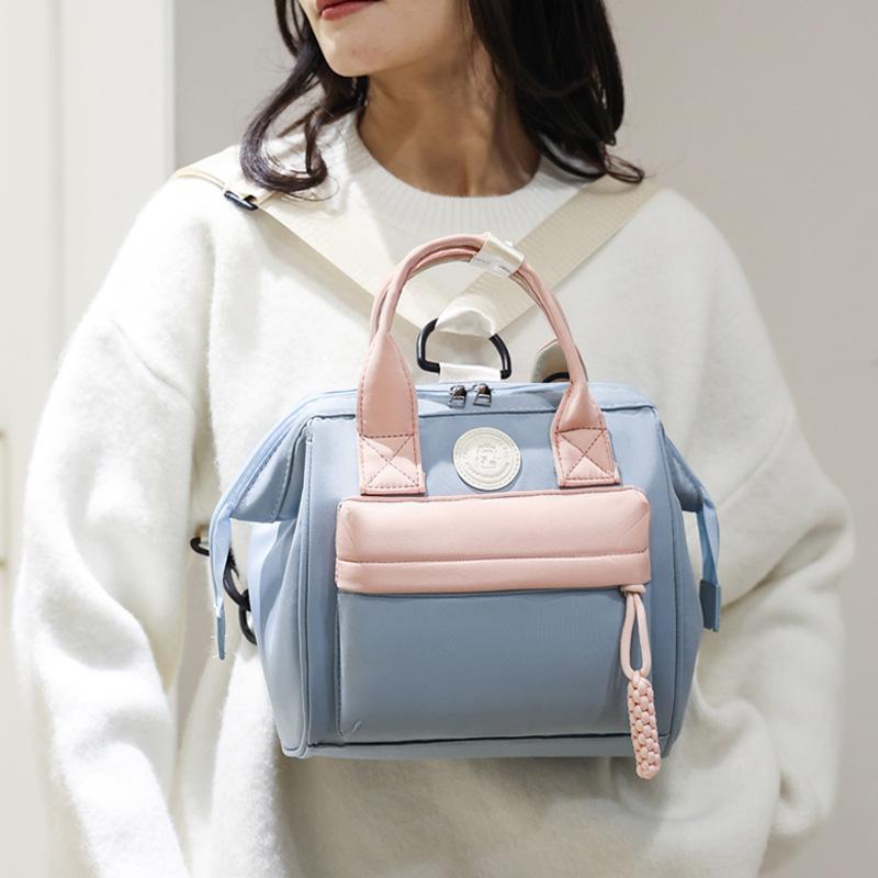 Cute, mini, and portable diaper bag for mothers, featuring a convenient handle and a backpack design for easy storage and carrying
