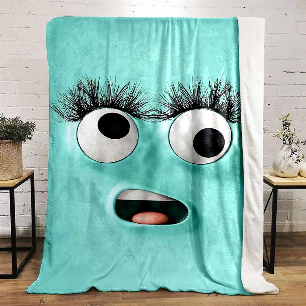 A playful turquoise face with large eyes, long lashes, and an open mouth. for all seasons blanket lunch break throw gift
