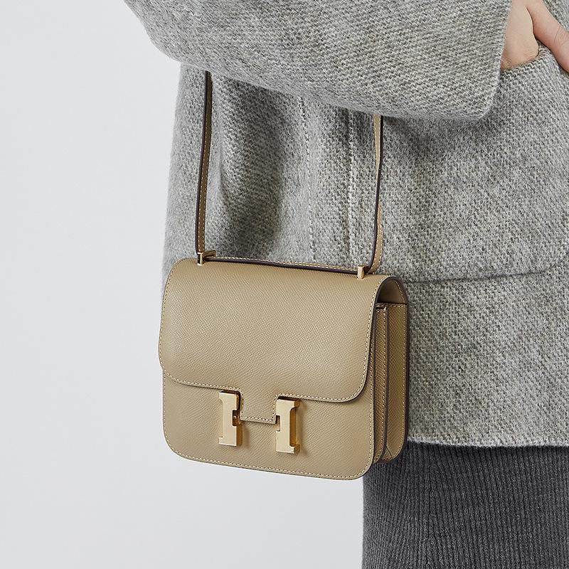 "2024 Кожаная сумка через плечо Kangkang с пряжкой H-образной формы: Модная, натуральная коровья кожа, универсальный дизайн на одно плечо.