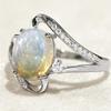 1A silver spiral design women's engagement ring with an oval synthetic opal at the center, accented with synthetic zirconia, is a fashionable