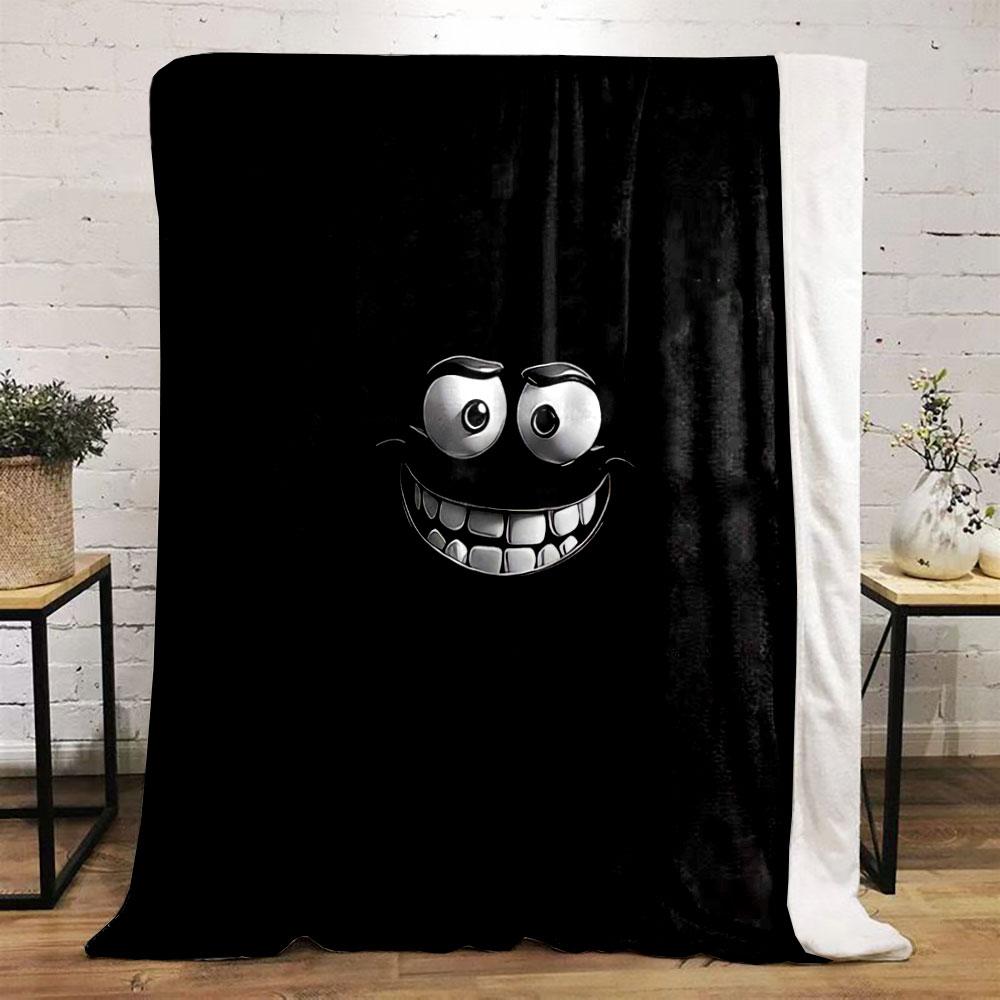A glowing, cartoonish face with wide eyes and a big toothy grin on black. for all seasons blanket lunch break throw gift