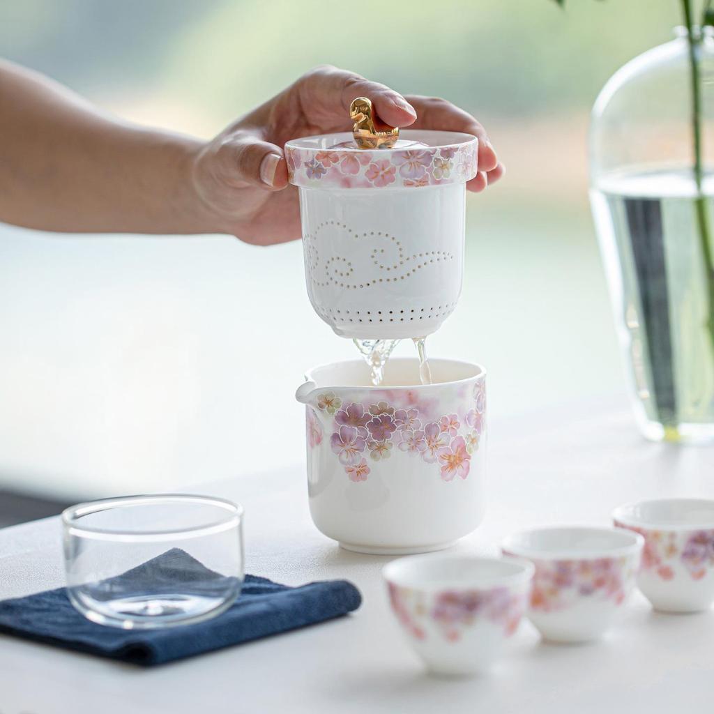 White Porcelain Floral Travel Tea Set: Includes One Pot, Three Cups, and Portable Bag.