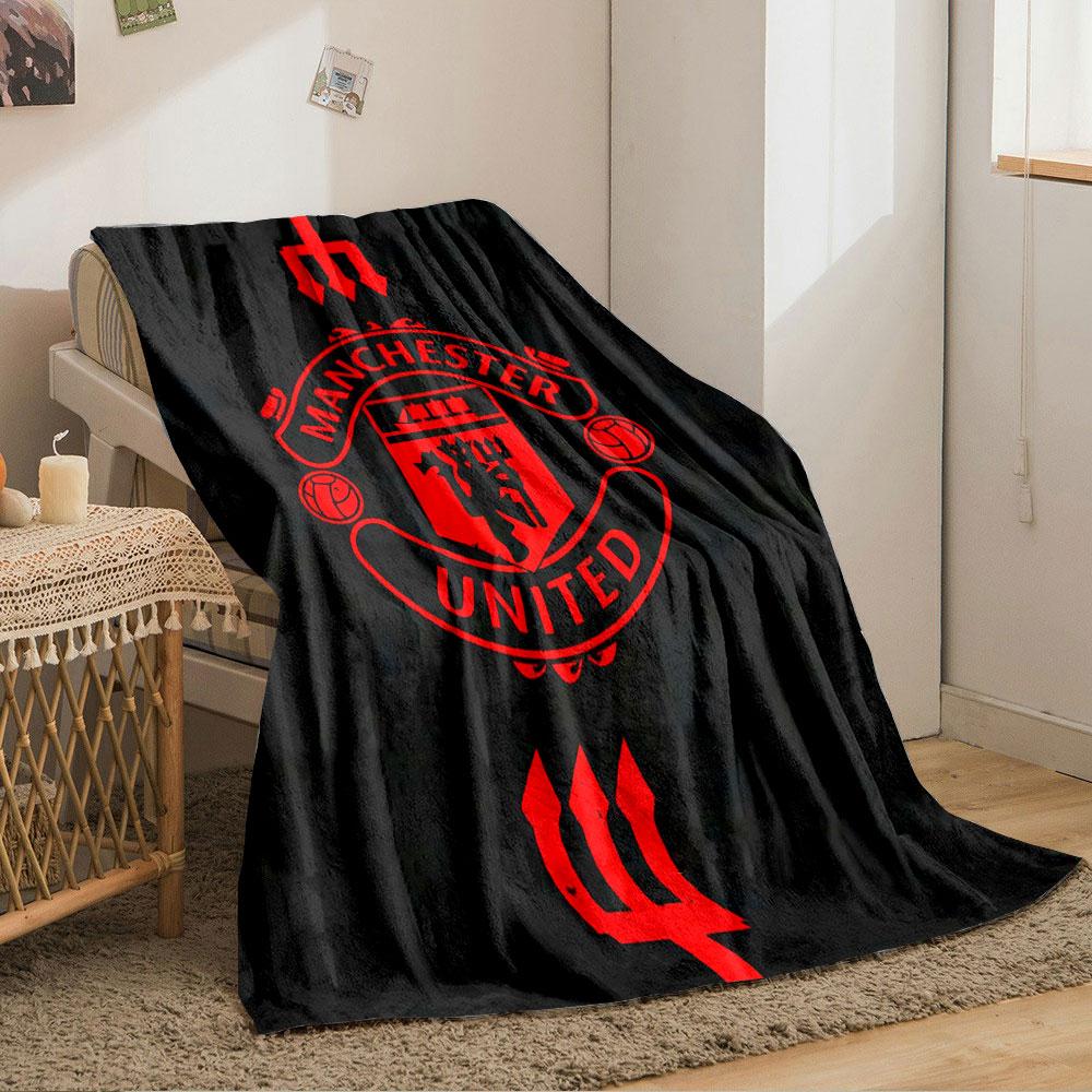 A red Manchester United emblem with tridents on a black background. for all seasons blanket lunch break throw gift