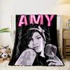 Dark-haired figure holding a retro microphone, beneath lit pink text "AMY". for all seasons blanket lunch break throw gift