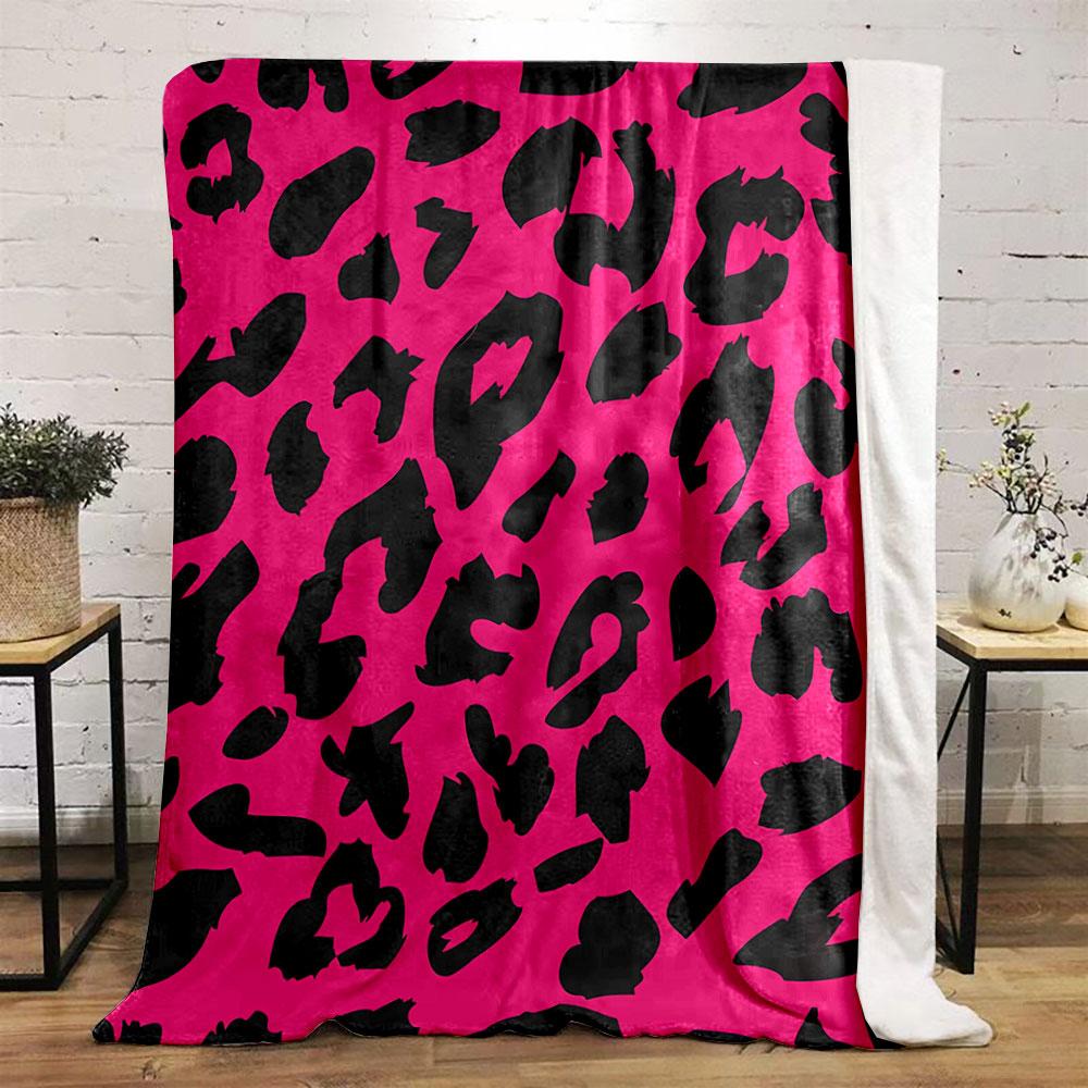 Black irregular shapes resembling leopard spots on a bright pink background. for all seasons blanket lunch break throw gift