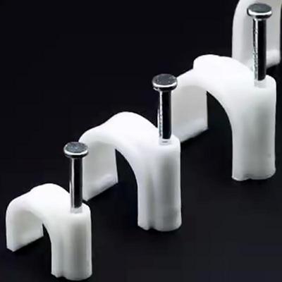 Цементная стена, стальной гвоздь, проволочный зажим и круглый трубчатый зажим