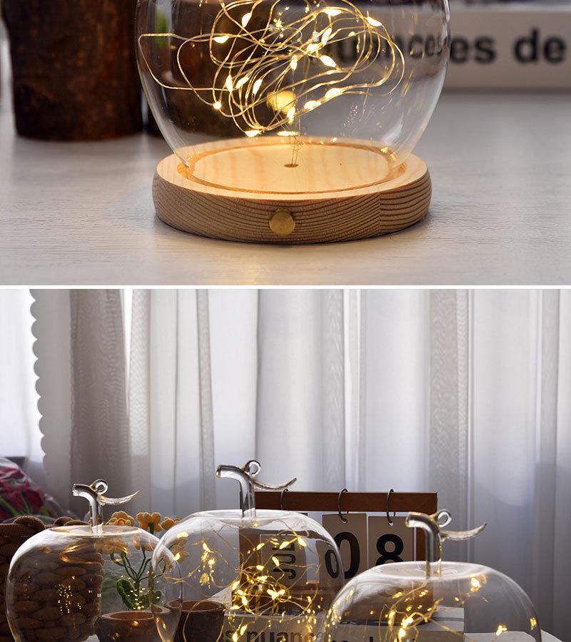 Купол из стекла с изображением вареных яблок и цветов, украшенный глиняной поделкой, для украшения рождественского стола.