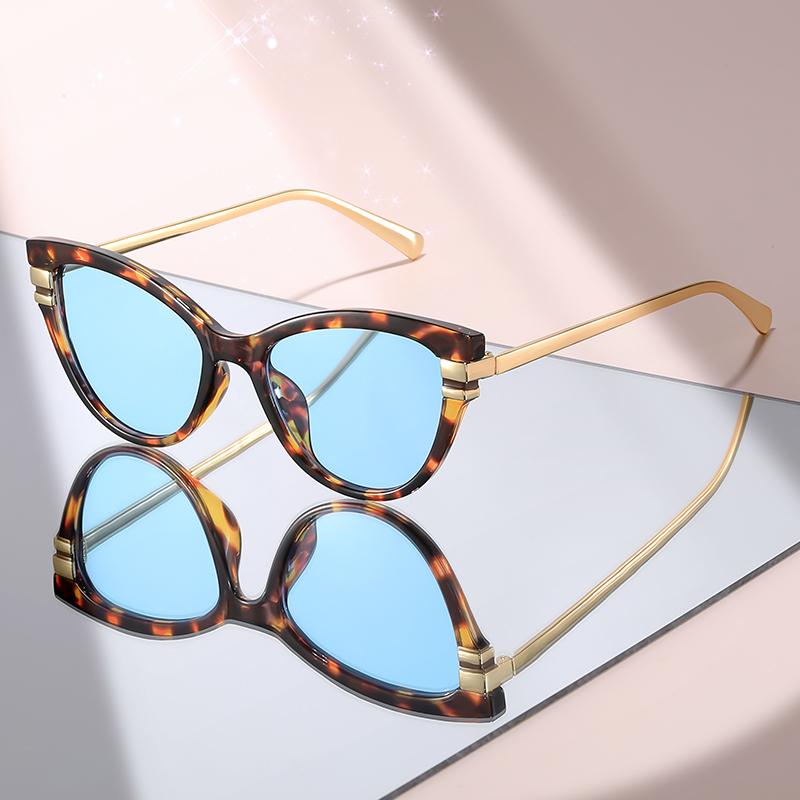 New Fashion Cat Eye Sunglasses with Black Top Frame, Red Patterned Lower Frame, Gold Metal Arms, and Gradient Brown Lenses for