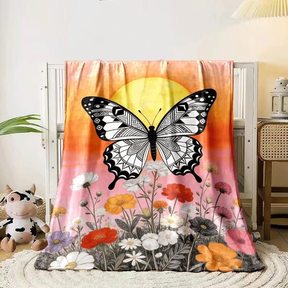 A black-and-white patterned butterfly over colorful flowers and a sunset. for all seasons blanket lunch break throw gift