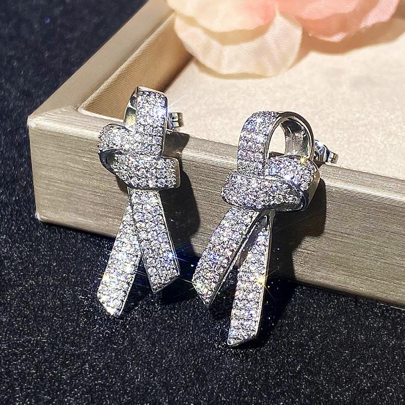 Huitan Серьги-пусеты в форме бантика для женщин, серебристого цвета, с сверкающими кристаллами кубического циркония, темпераментные аксессуары, женские украшения