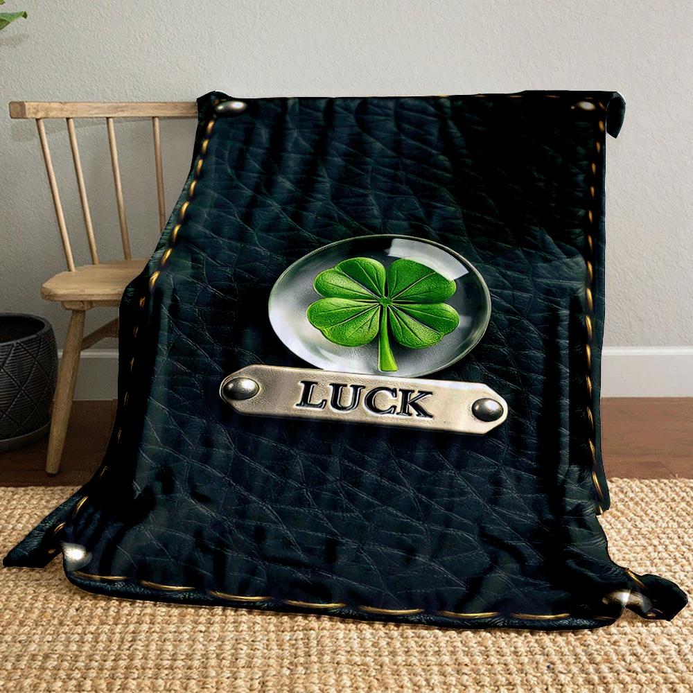A four-leaf clover encased in glass, labeled "LUCK" on stitched leather. for all seasons blanket lunch break throw gift