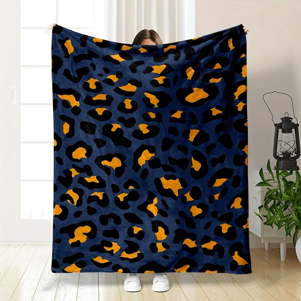 A leopard print pattern with orange and black spots on a navy background. for all seasons blanket lunch break throw gift
