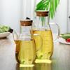 Стеклянная бутылка для масла из высокоборосиликатного стекла с мерной шкалой и защитой от протечек для кухни.