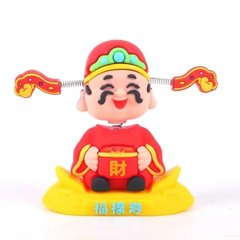 Shaking his head the little God of Wealth car ornament has and the God console is creatively decorated to attract wealth and receive blessing