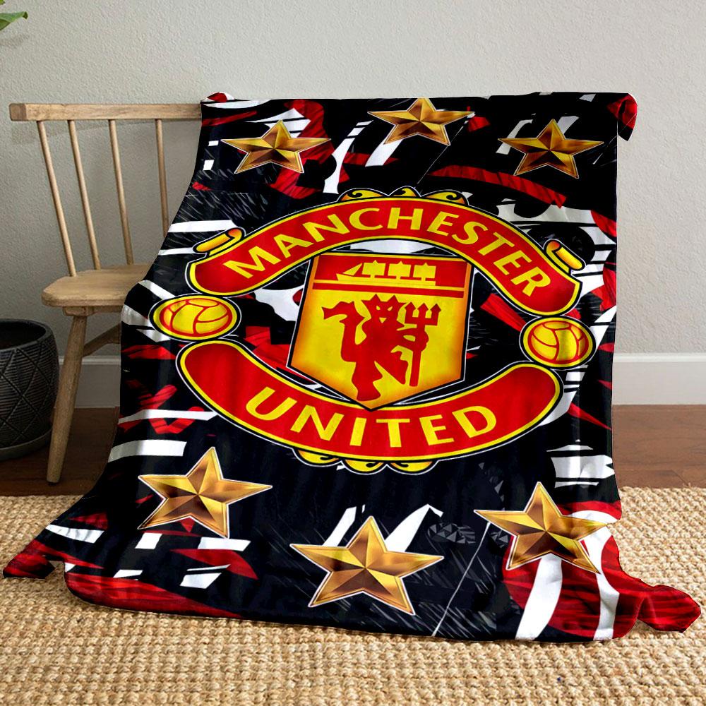 A Manchester United logo surrounded by gold stars on a red-black pattern. for all seasons blanket lunch break throw gift