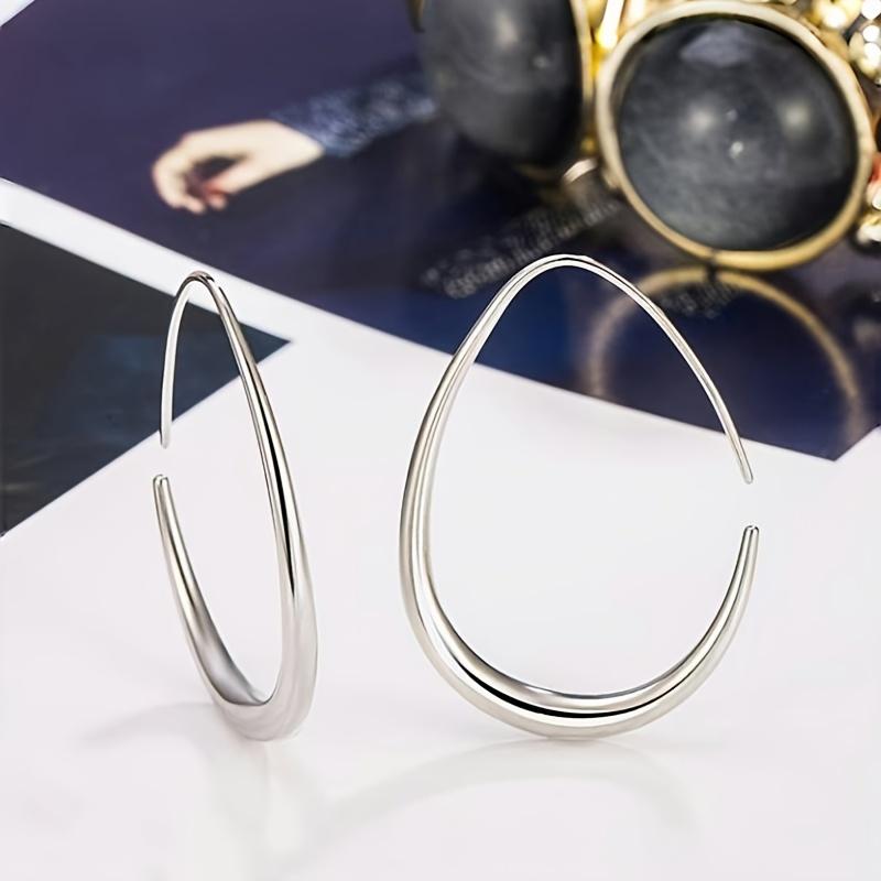 A Pair Of Minimalist Chic Teardrop-shaped Hoop Earrings, Exuding Elegance, Perfect For Ladies To Wear To Parties And Vacations.