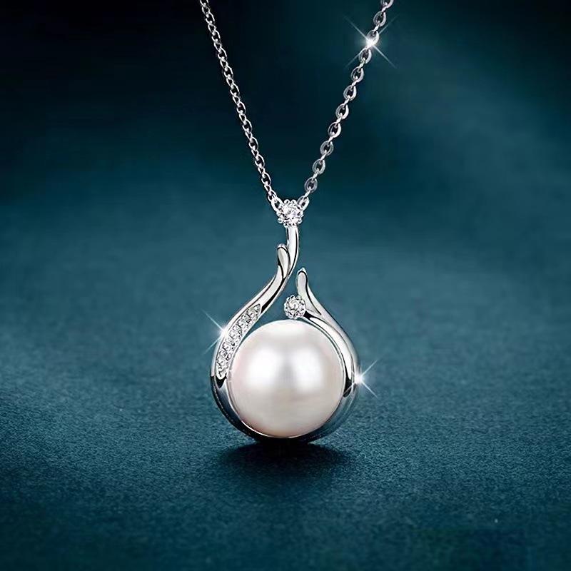 A Vintage Teardrop-Shaped Necklace Adorned With A Faux Pearl Pendant And Pomegranate Seed Design, Perfect For Everyday Wear By Women.