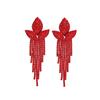 Красные и черные длинные серьги с трехлистным цветком и бахромой.