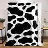Black irregular spots on a white background resembling a cow print. for all seasons blanket lunch break throw gift