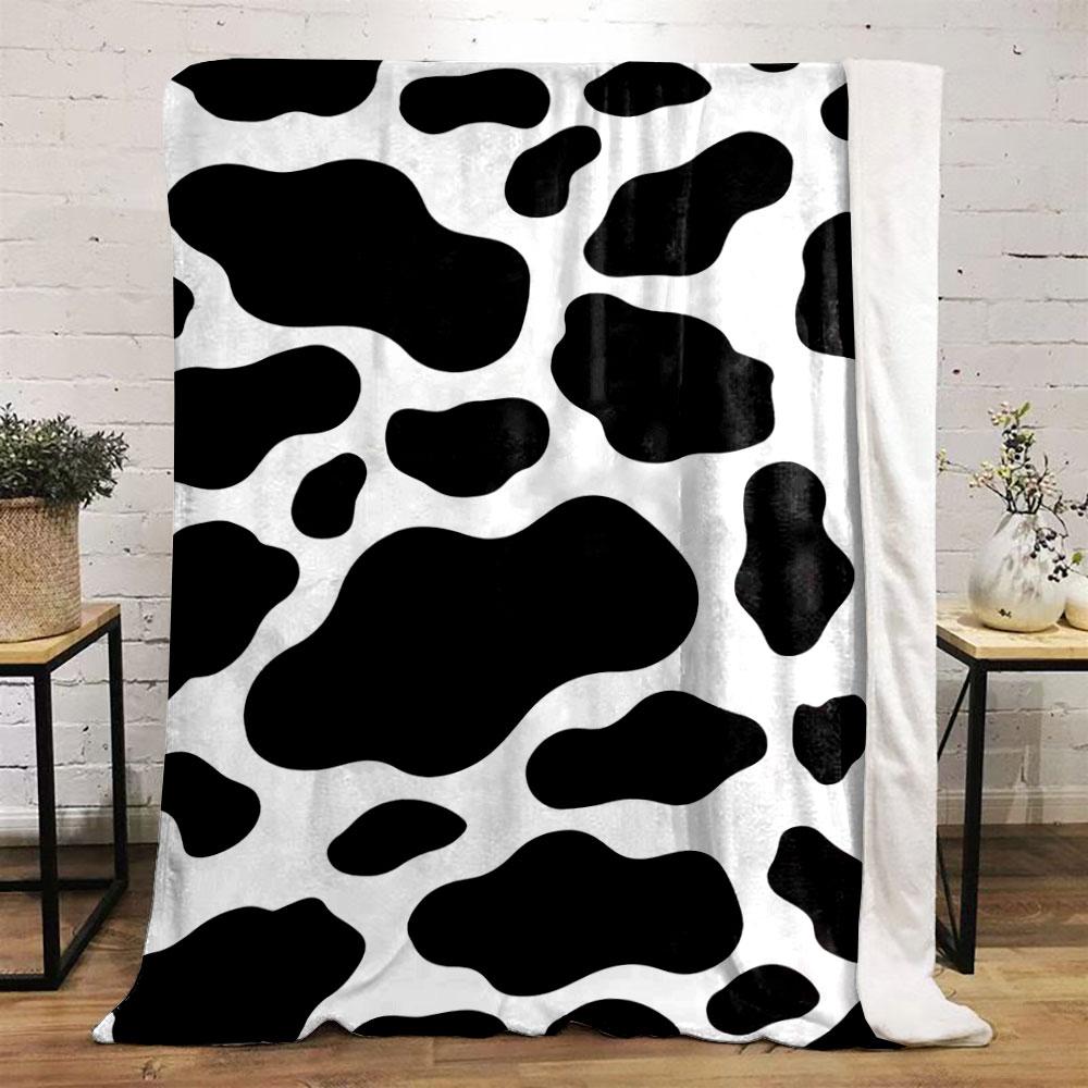 Black irregular spots on a white background resembling a cow print. for all seasons blanket lunch break throw gift
